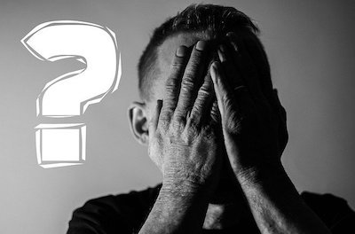 両手で顔を覆う男性